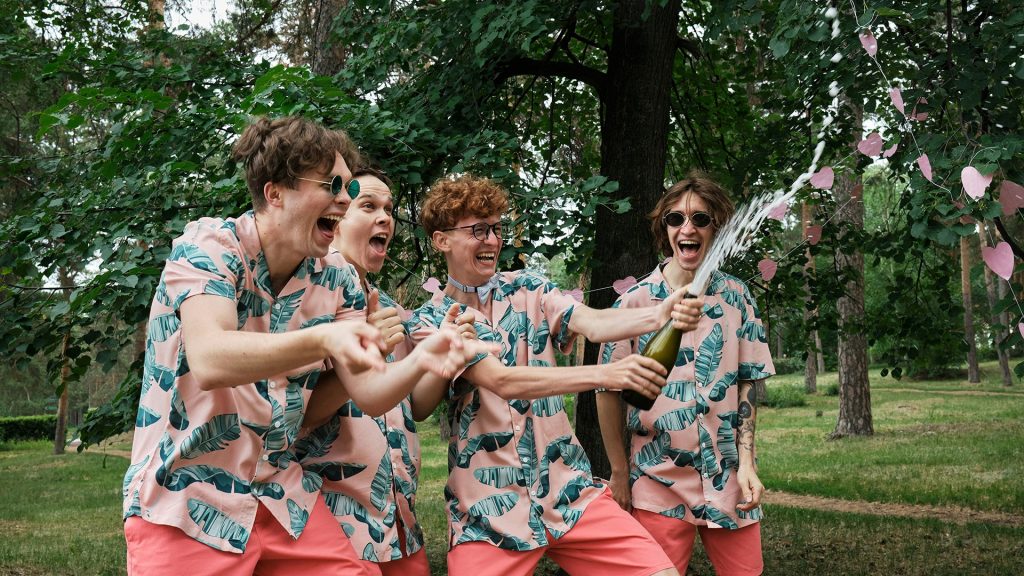 men popping champagne